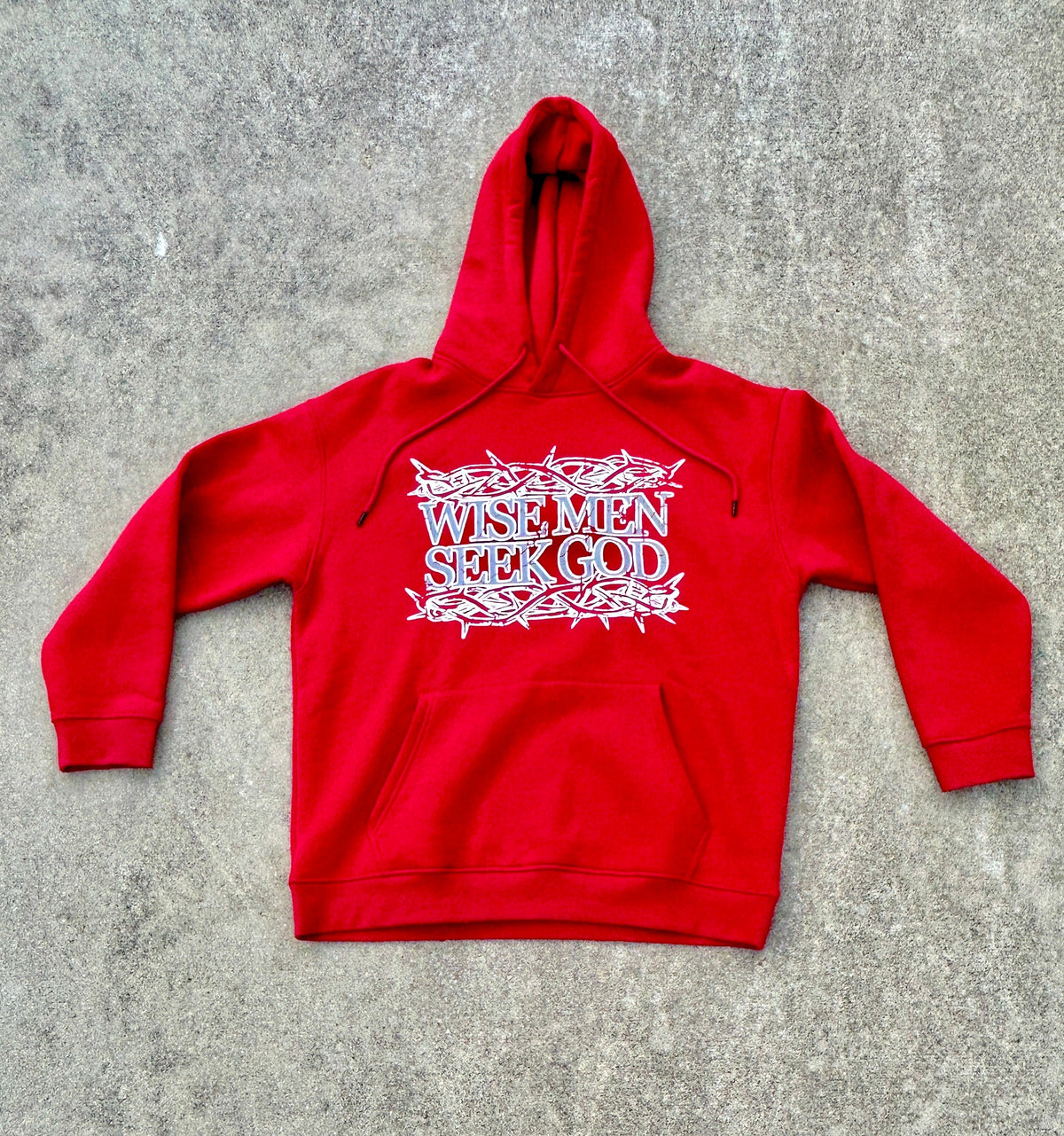 Red hoodie with Christian text on a gray surface